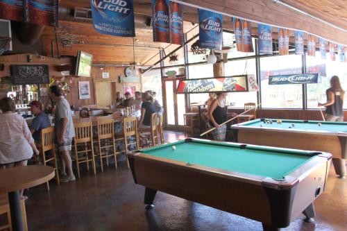 a pool table in a bar with people in a restaurant at The Pines Resort & Conference Center in Bass Lake