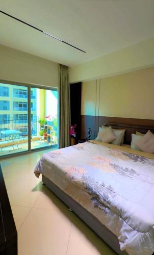 a bedroom with a large bed and a large window at شقة خاصة in Muharraq
