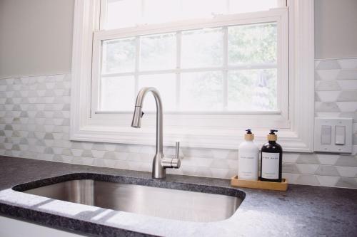 a kitchen sink with two bottles on a counter at Hidden Gem Farm Homestead Sleeps 12 &Fresh Produce in Spring Hill