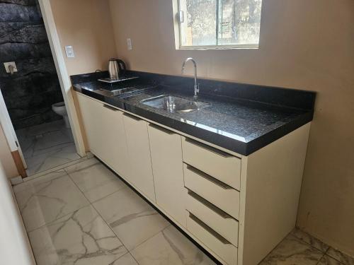 a bathroom with a sink and a toilet at Urban Center Apartamentos in Salto del Guairá