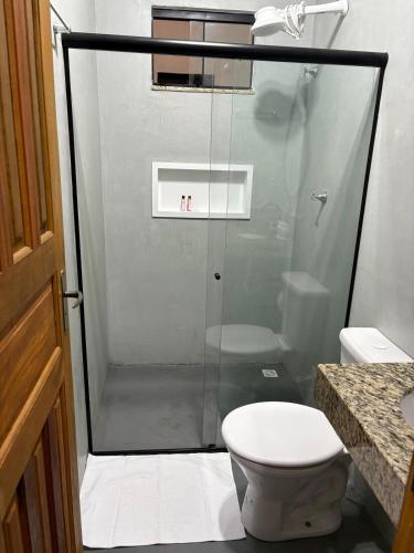 a bathroom with a glass shower with a toilet at Studio 04 in Aracruz