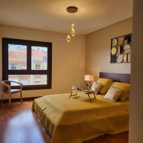 Schlafzimmer mit einem Bett mit einem Tisch und einem Fenster in der Unterkunft Spacious 2BR near Odivelas Metro with Balcony in Odivelas