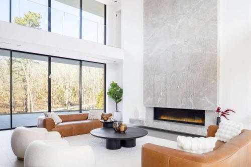 a living room with couches and a fireplace at Brightwater by Rove Sauna Pool & Outdoor Spaces in Freetown