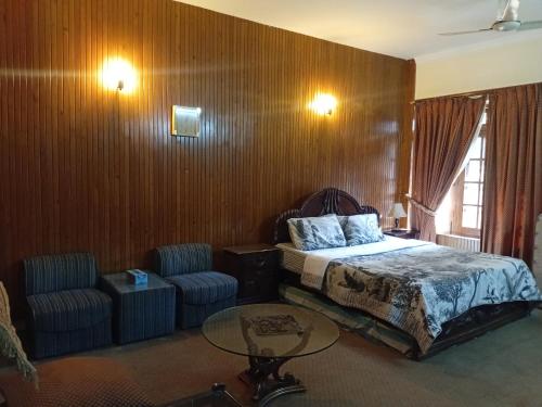 una camera da letto con un letto, un tavolo e delle sedie di Naim Ullah Tiwana a Lahore