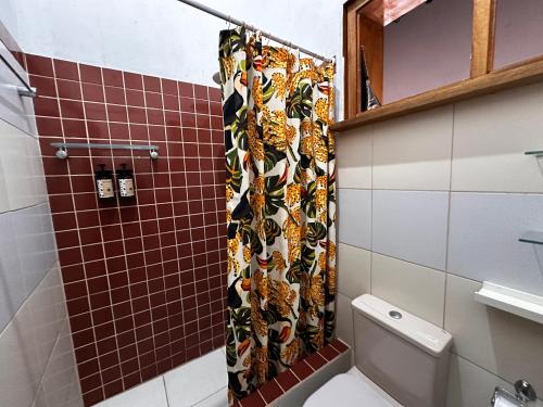 une salle de bain avec un rideau de douche et des toilettes dans l'établissement Cervejaria Guest House, à Île de Boipeba