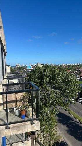 a balcony with potted plants on top of a building at Bright on the avenue in Mar del Plata