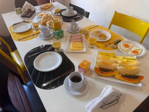 een tafel met borden met eten en drinken erop bij Cervejaria Guest House in Ilha de Boipeba