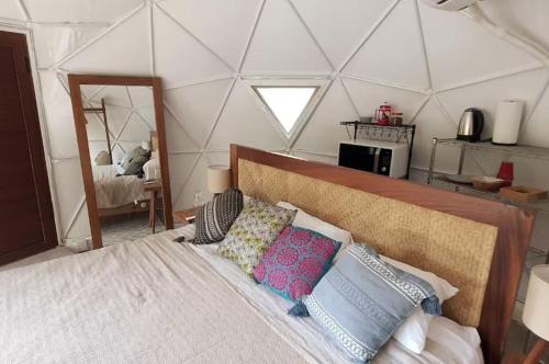 een slaapkamer met een groot bed met kussens erop bij Cupi Glamping in San Francisco