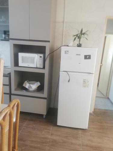 a white refrigerator in a kitchen with a microwave at La Abuelita in Rocha