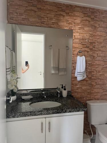 a bathroom with a sink and a brick wall at Residencial Neo 1 in Maceió