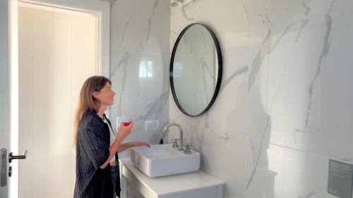 a woman standing in a bathroom with a sink at Casa Molino - Casa en Complejo Land Houses A Dos cuadras de Cruz del Sur, Chapadmalal - Hola Sur in Chapadmalal