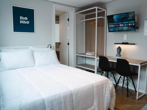 um quarto com uma cama e uma secretária com cadeiras em Apê Itaim Bibi - Soft Opening em São Paulo