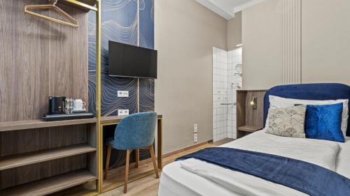 a bedroom with a bed and a desk and a tv at Nestroyplatz Rooms I Self Check In in Vienna