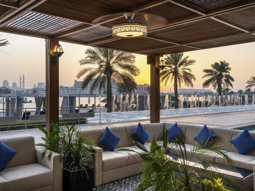 a living room with a couch and palm trees at Fairmont Bab Al Bahr in Abu Dhabi