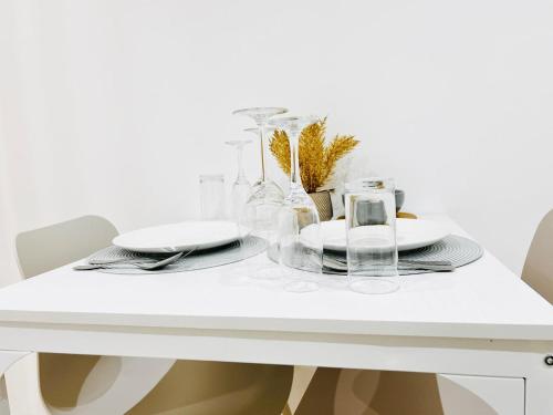 - une table blanche avec des assiettes et des verres dans l'établissement Élégant studio rénové Confort et tranquillité, à Saint-Quentin