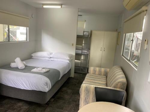 a small bedroom with a bed and a chair at NRMA Bairnsdale Riverside Holiday Park in Bairnsdale