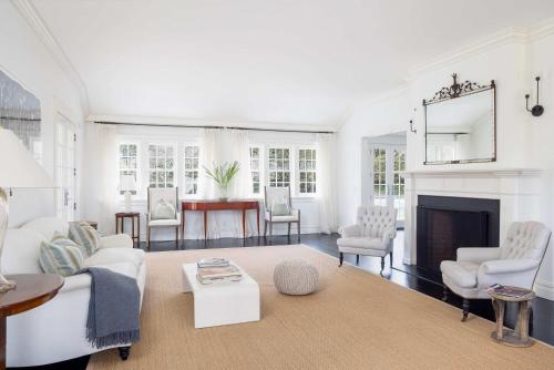 a living room with white furniture and a fireplace at Oceanstone by Rove Villa w Pool & Beach Access in Southampton