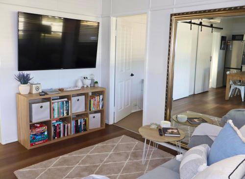 a living room with a large mirror on the wall at The Corner Cottage in Mudgee