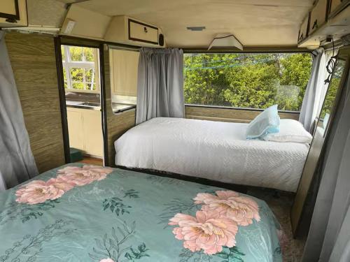 ein Schlafzimmer mit zwei Betten in einem Wohnmobil in der Unterkunft Simple Cabin, Kuaotunu - Peaceful, Affordable Stay in Kuaotunu
