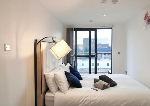 a bedroom with a bed with pillows and a lamp at Modern Duplex apartment City Centre Manchester in Manchester