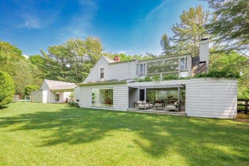 a large white house with a lawn in front of it at Cowhill Cottage by Rove Home with Pool & Lounge in Wainscott