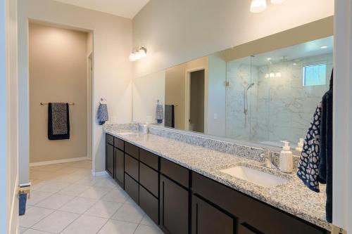 een badkamer met een wastafel en een grote spiegel bij Dove Mountain Gem! in Marana