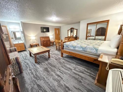 a hotel room with a bed and a table at Regency Inn in Dodge City