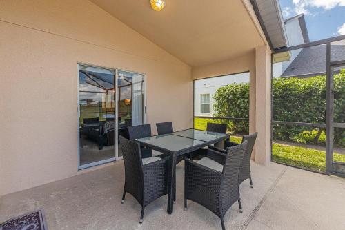 a dining room table and chairs on a patio at Simba's Lake House in Orlando