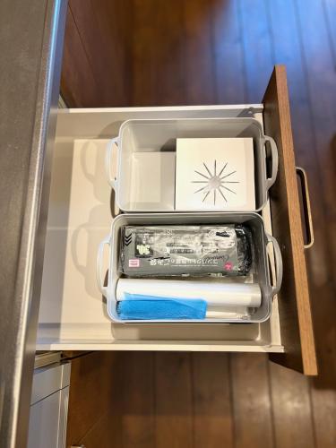 an open refrigerator drawer with a cell phone in it at 薪ストーブが体験できるログハウス #貸別荘 #一棟貸切 #グループ旅行や家族旅行におすすめ #札幌市内から好アクセス #満天の星空 #木の香り #BESS札幌 #cape in Sapporo