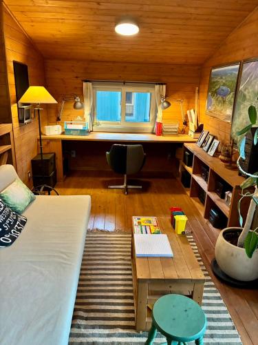 a room with a bed and a desk and a table at 薪ストーブが体験できるログハウス #貸別荘 #一棟貸切 #グループ旅行や家族旅行におすすめ #札幌市内から好アクセス #満天の星空 #木の香り #BESS札幌 #cape in Sapporo