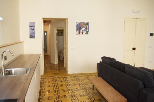 a living room with a couch and a kitchen at Valletta Mint Apartment 1 in Valletta