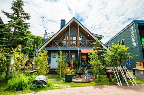 a house with a dog sitting in front of it at 薪ストーブが体験できるログハウス #貸別荘 #一棟貸切 #グループ旅行や家族旅行におすすめ #札幌市内から好アクセス #満天の星空 #木の香り #BESS札幌 #cape in Sapporo