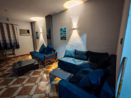 un salon avec un canapé bleu et des chaises dans l'établissement قرية النورس, à Ismaïlia