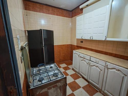 une cuisine avec une cuisinière et un réfrigérateur dans l'établissement قرية النورس, à Ismaïlia