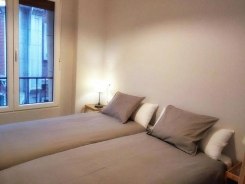 una camera da letto con due letti e una finestra di En el centro entre el puerto y las playas a Gijón