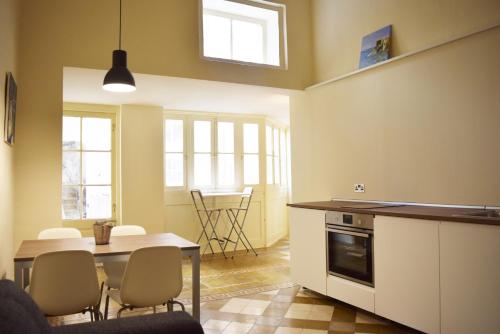 a kitchen with a table and a dining room at Valletta Mint Apartment 1 in Valletta