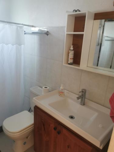 a bathroom with a sink and a toilet and a mirror at Lo de Mary in Rocha