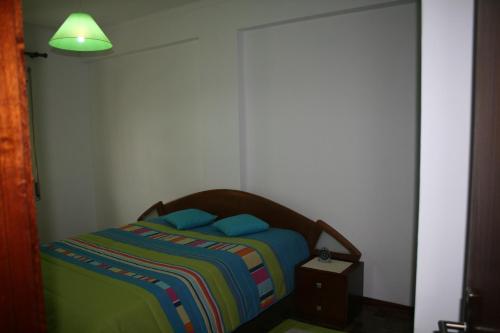 サン・マルティーニョ・ド・ポルトにあるApartamento Conde de Avelarのベッドルーム1室(カラフルな毛布付きのベッド1台付)