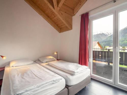 two beds in a room with a large window at Kipaji 3 in Kötschach