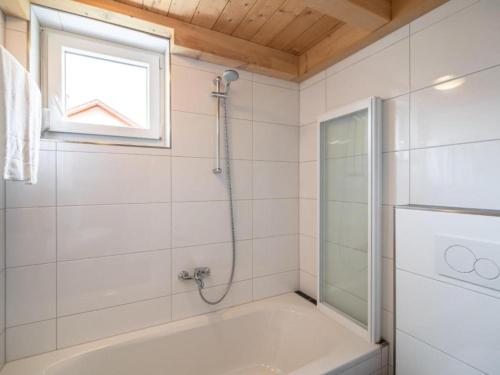 a bathroom with a bath tub and a window at Kipaji 3 in Kötschach