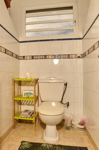 a bathroom with a white toilet in a room at Le Flamboyant in Saint-Louis