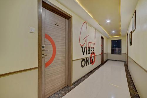 a hallway with a door and a sign on the wall at Collection O Pune Railway Station Formerly Kapil Residency in Pune