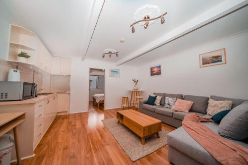 a living room with a couch and a table at Mollymook Beach getaway in Mollymook