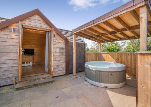 a hot tub on a patio with a wooden house at South View Retreat in Carlton