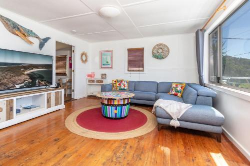 a living room with a couch and a table at Surf Shack at Boat Beach in Seal Rocks
