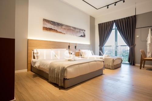 a bedroom with a large bed and a large window at Bay Suites by Pinstay Plus in Kota Kinabalu