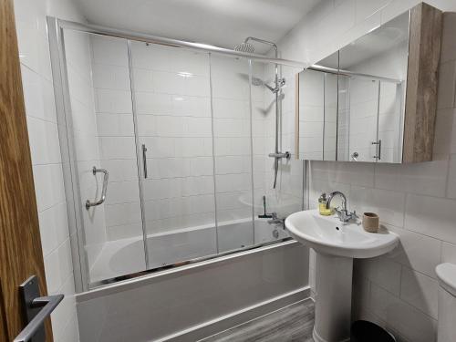 ein Badezimmer mit Dusche, Waschbecken und Badewanne in der Unterkunft Seashells Cottage in Lytham St Annes