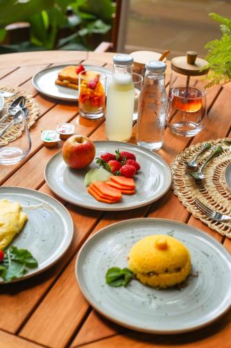 uma mesa de madeira com pratos de comida sobre ela em Saluz Boutique Hotel em Jericoacoara