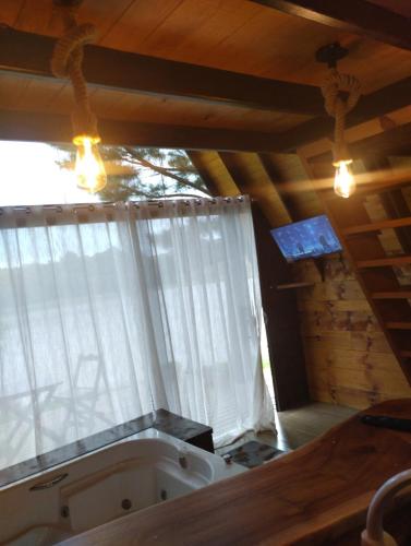 a bath tub in a room with a window at Chalé do lago in Campo Alegre