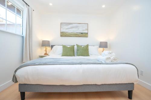 une chambre avec un grand lit avec des oreillers verts dans l'établissement Spacious SJ 4BR Home Prime Location Near Everything, à San José